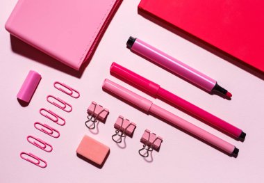 Defter, kalem büyük yalan pembe bir arka plan üzerine