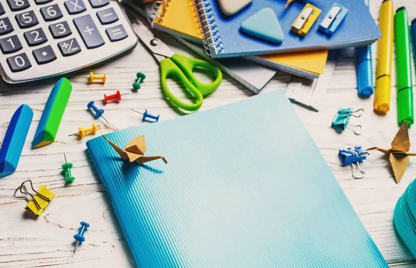 De vuelta a la escuela. Un cuaderno azul yace sobre una mesa blanca . — Foto de Stock
