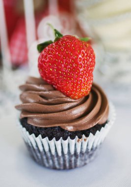 Masanın üzerine çilek ile çikolatalı kek.