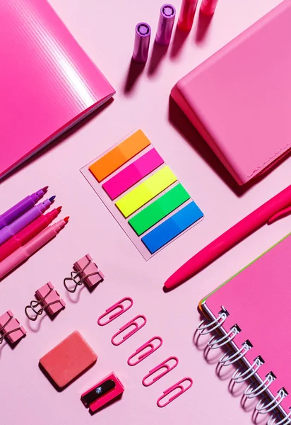 Kleur van de stickers, roze notitieboekjes, paperclips, markeringen, elastiek en puntenslijper — Stockfoto