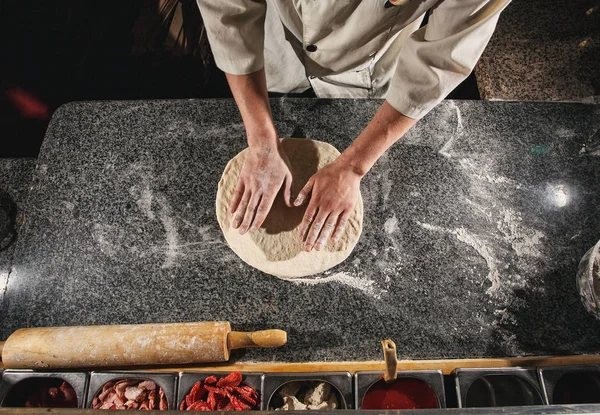 Conceder una forma de masa. Masa para pizza — Foto de Stock