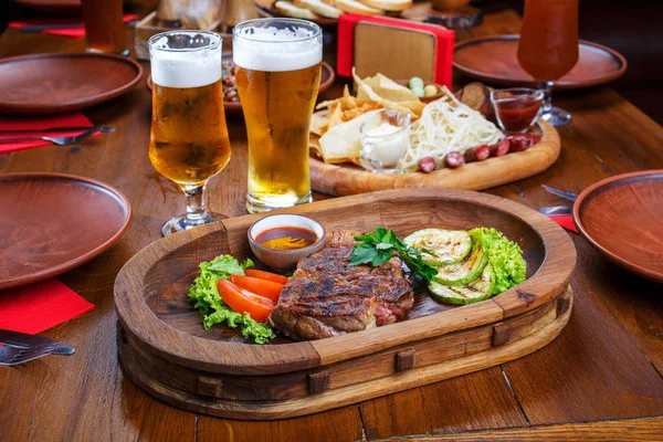 Scharfes Steak mit Sauce und Gemüse. auf einem Holztisch — Stockfoto