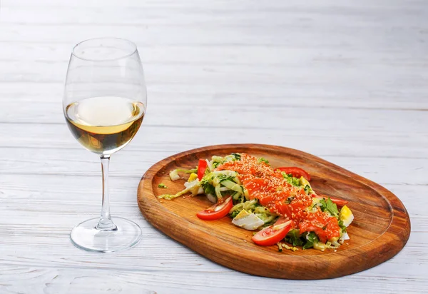 Pescado rojo con sésamo en verduras con una copa de vino blanco — Foto de Stock
