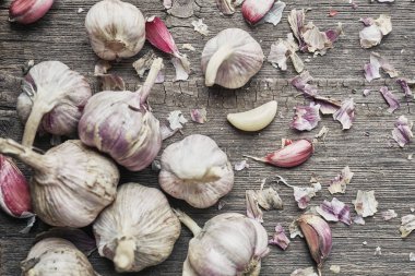 Sarımsak kabuğu ile. Ahşap bir zemin üzerine sarımsak yakın çekim.