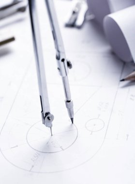 Bir pusula ile daireler çizmek öğrenmek. Pergel ve mimar ölçek cetveli masanın üzerine yerleştirilen planları bina ile dolu. seçici odak