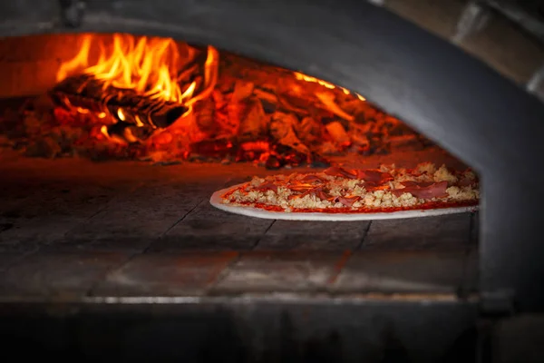 Pizza in the oven. Pizza with ham, Bulgarian pepper and cheese