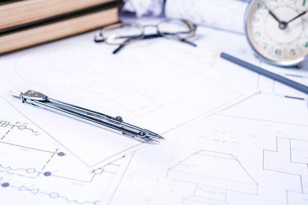 Old watch with eyeglasses and compass on industrial drawings