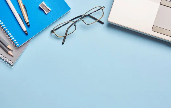 Sobre un cuaderno de fondo azul y papelería de oficina — Foto de Stock