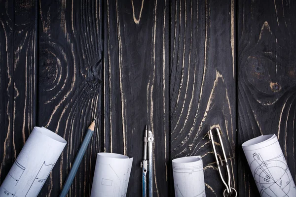 Compasses, rolos do desenho e um lápis em uma madeira escura — Fotografia de Stock