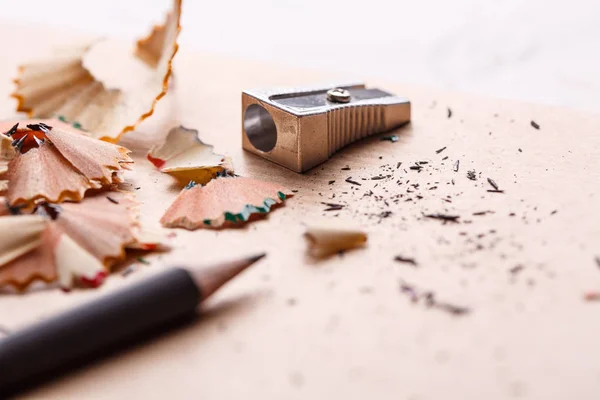 Ein scharfer grauer Bleistift mit einem Metallspitzer auf dem Tisch — Stockfoto