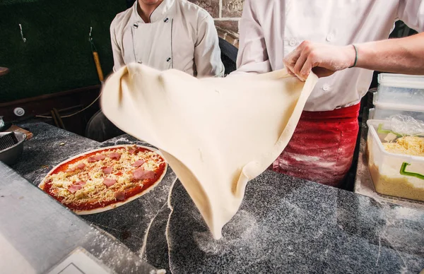La preparación de la masa de pizza, la masa en el vuelo . — Foto de Stock