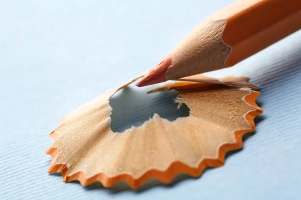 Mavi arka plan üzerinde talas ile turuncu kalem — Stok fotoğraf
