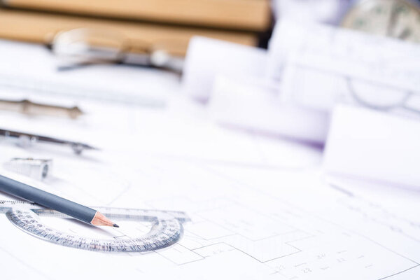 Pencil with a protractor against the background of the engineer's desk