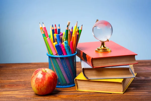 Bright stationery next to books and an apple — Stock Photo, Image