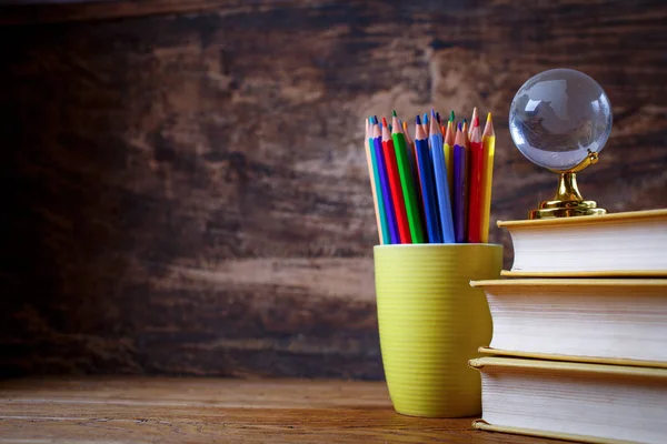 Globe on books and pencils on a student table — Stock Photo, Image