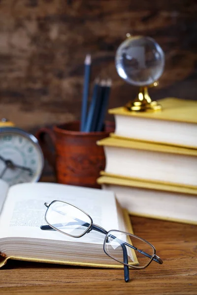 An open book with eyeglasses in the library — Stock Photo, Image