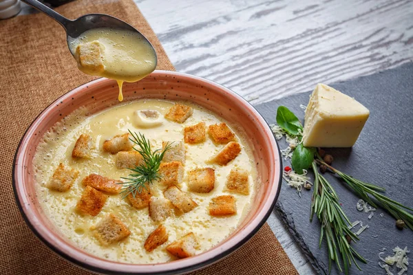 Soupe à la crème gouttes d'une cuillère dans une assiette — Photo