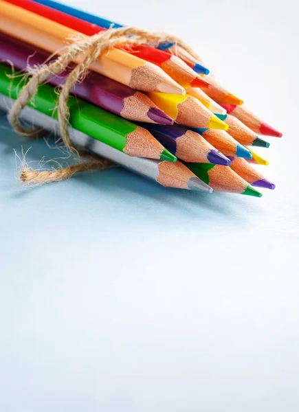 En grupp av ljusa trä blyertspennor liggande på en blå bakgrund — Stockfoto
