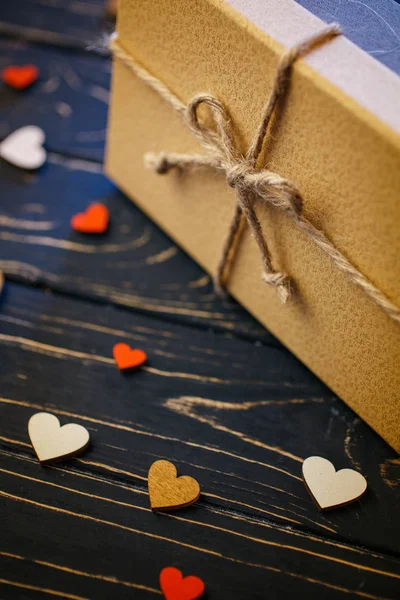 Scatole regalo marroni su sfondo di legno con un fiocco di un semplice primo piano di corda — Foto Stock