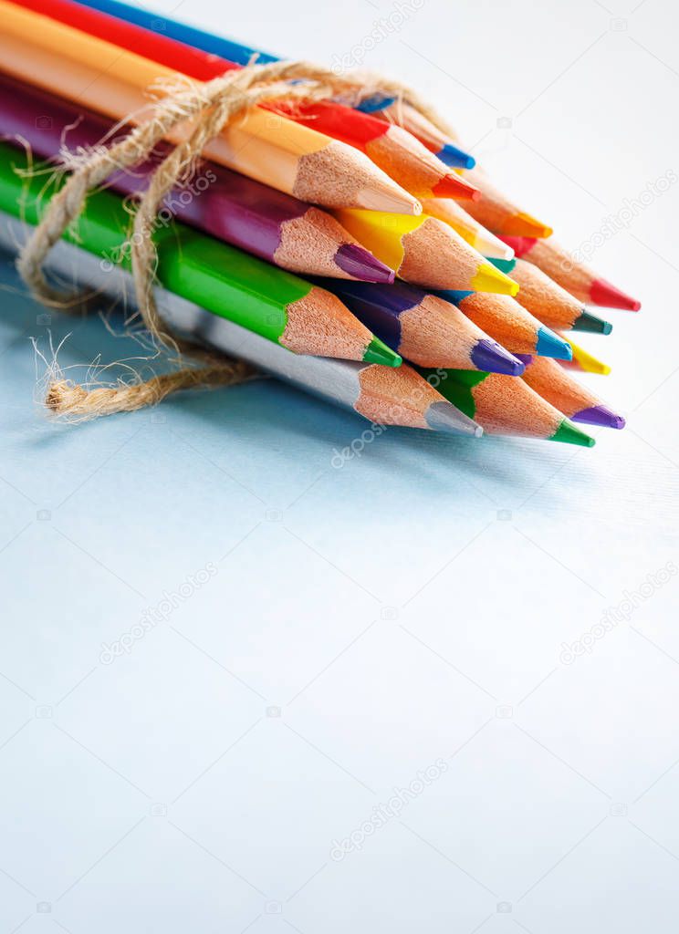 A group of bright wooden pencils lying on a blue background
