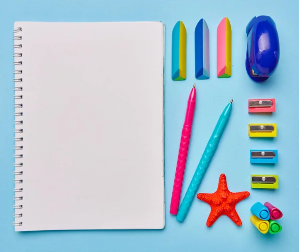 Schulsachen liegen auf einem hellblauen Tisch — Stockfoto