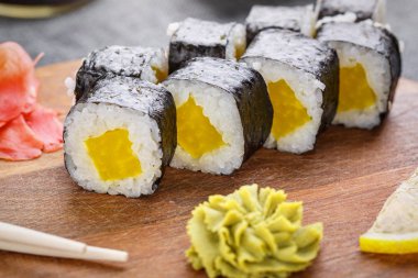 Kırmızı balık ve lemo yanında tahtaüzerinde ananas ile Ince rulo