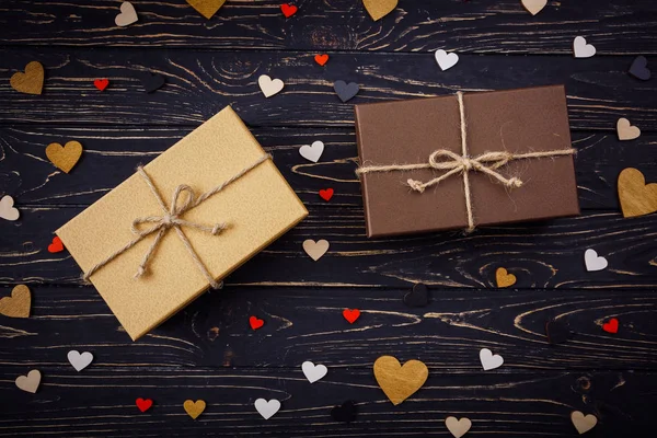 Dos cajas de regalo marrones sobre un fondo de madera con un lazo de simp — Foto de Stock