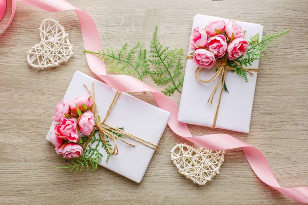 Composición con cajas de regalo decoradas con rama verde, rosa, w — Foto de Stock