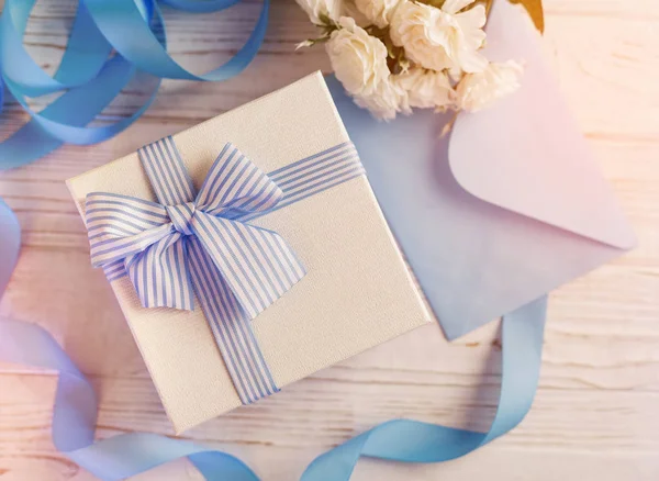 Gift box with blue ribbon and bow. Simple composition with present wrapped. — Stock Photo, Image