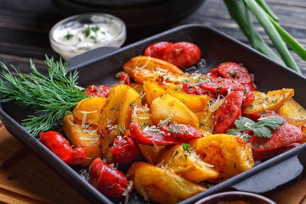 Potato baked with sausages and decorated with herbs. — Stock Photo, Image