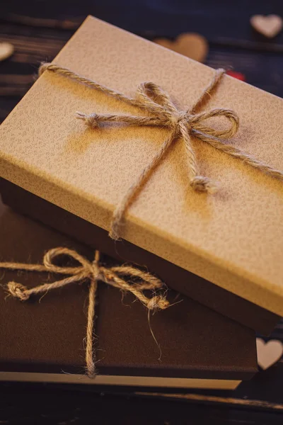 Dos cajas de regalo marrones sobre un fondo de madera con un lazo de simp —  Fotos de Stock