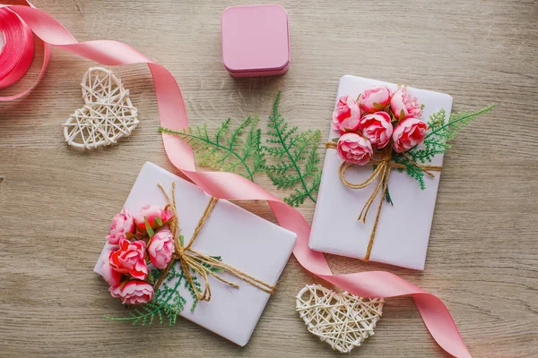 Eco style gift wrapping. Composition with gift boxes decorated with green branch and rose. — Stock Photo, Image