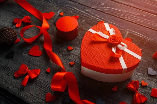 Caja de regalo en forma de corazón con corazones de fieltro y cinta de satén sobre un fondo de madera. Composición con regalo, caja de regalo, corazones rojos . —  Fotos de Stock