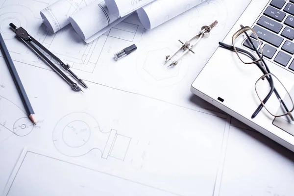 Laptop, Glasögon, blyertspenna, kompass och rullar ritningar på bordet i Engineering — Stockfoto
