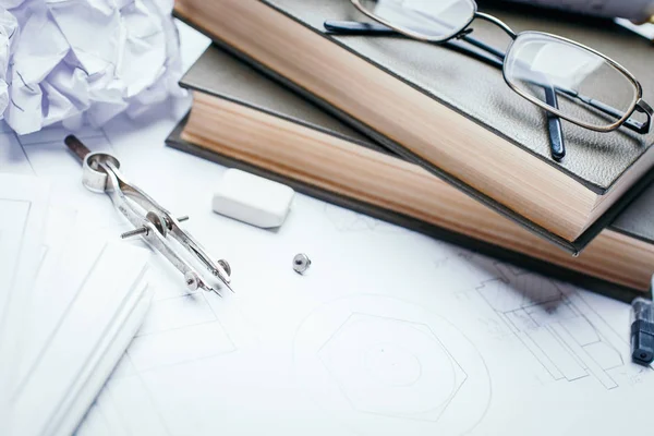 Книги, стаканы, карандаш, компас и рулоны чертежей по деталям промышленных чертежей — стоковое фото