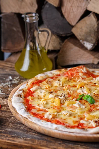 Odun ve zeytinyağı arka planda tavuk ve ananas ile Pizza — Stok fotoğraf