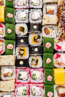 Japon suşi yemeği. Maki ve rulo ton balığı, somon, karides, yengeç ve avokado. Çeşit çeşit suşinin üst görünümü.