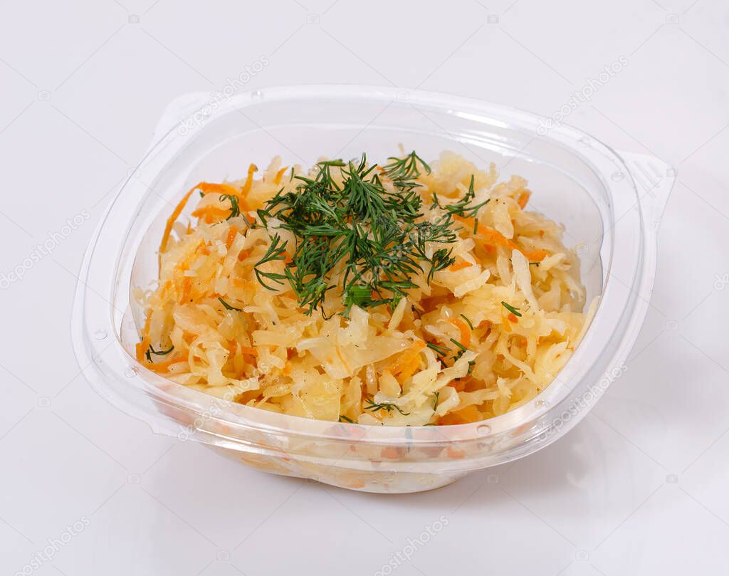 Traditional salad of cauliflower, carrots, onions and dill in a transparent plastic bowl on a white background.