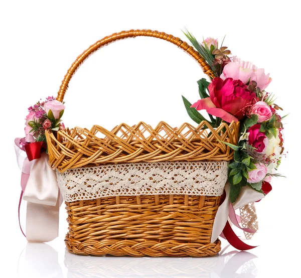 イースターバスケット。カラフルな花の装飾と白い背景に着色されたリボンを持つ茶色のウィッカーバスケット。イースターのお祝いのための美しいバスケットデザイン. — ストック写真
