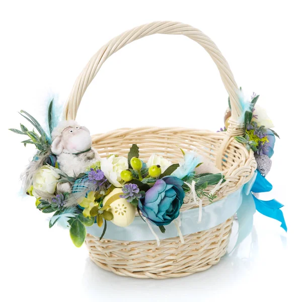 Velikonoční košík na bílém pozadí. Zdobené květinami v modré a malé dekorativní ovce. Stuhy a krajky. — Stock fotografie