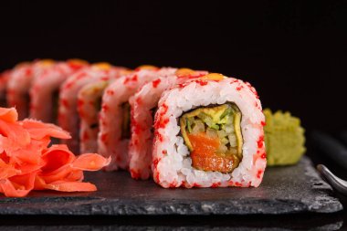 Kırmızı havyar, taze somon, krem peynir, salatalık, avokado. Zencefil ve wasabi ve siyah seramik kaplama ile servis edilir..