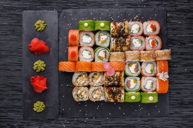 Japon suşi yemeği. Maki ve rulo ton balığı, somon, karides, yengeç ve avokado. Çeşit çeşit suşinin üst görünümü.