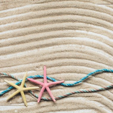 Yaz tatili geçmişi. Kumsaldaki renkli deniz yıldızı. Dalgalı kum dokusu. Kopyalama alanı olan üst görünüm.