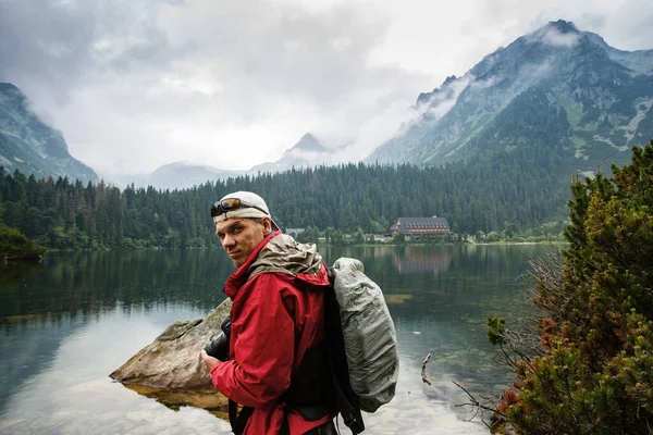 Homem fica perto do Lago Popradskoe Pleso em altas montanhas Tatras. — Fotografia de Stock