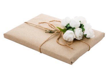 Çiçeklerle süslenmiş el sanatları kağıdına sarılmış orijinal bir hediye. Beyaz arkaplan ve kırpma yolu üzerinde izole.