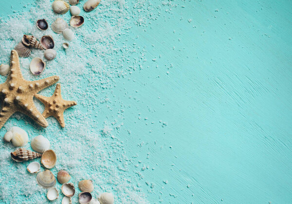 Creative flat lay concept of summer travel vacations. Seashells and starfish on turquoise blue background. Template for text.