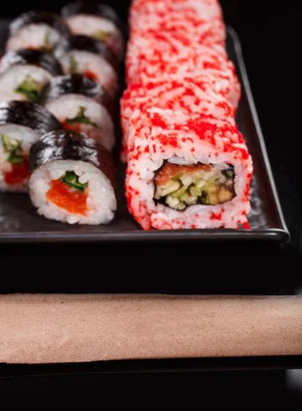 寿司套餐 乌拉麦和Maki配以红鱼子酱 鲑鱼和黄瓜 在黑盘上服役 日本菜 — 图库照片
