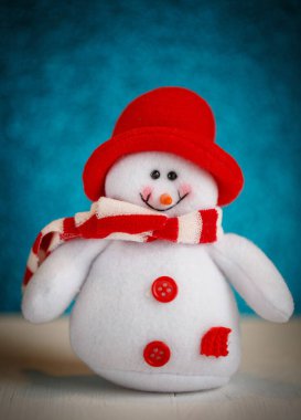 Atkı ve şapka takmış gülümseyen kardan adam oyuncağı..