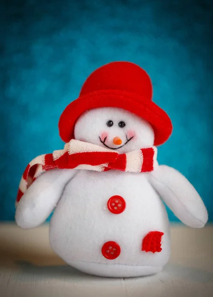 Uśmiechnięta zabawka bałwana ubrana w szalik i czapkę. — Zdjęcie stockowe