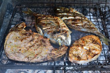 Ton balığı ve Swordfish biftek ve iki deniz barbun bitmek üzere, ızgara, baharatlar ile görünümü yan